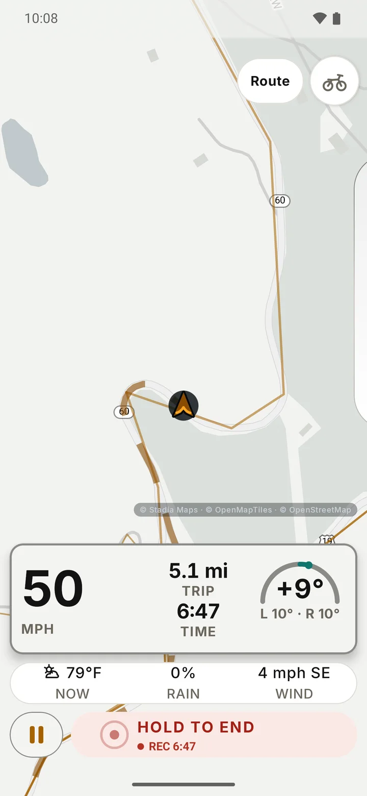 RIDE riding screen on a hairpin of a twisty road: speed 50 mph, trip 5.1 miles, ride time, a live lean reading with the left and right maximums both filled in, a weather strip and Hold to end.